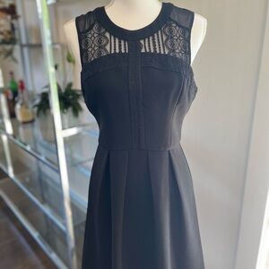 Tasteful little black dress. Lace and pleat details. Cute little back cutout.